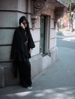 Elegant woman in black attire posing on a street in Mexico City, showcasing urban fashion.