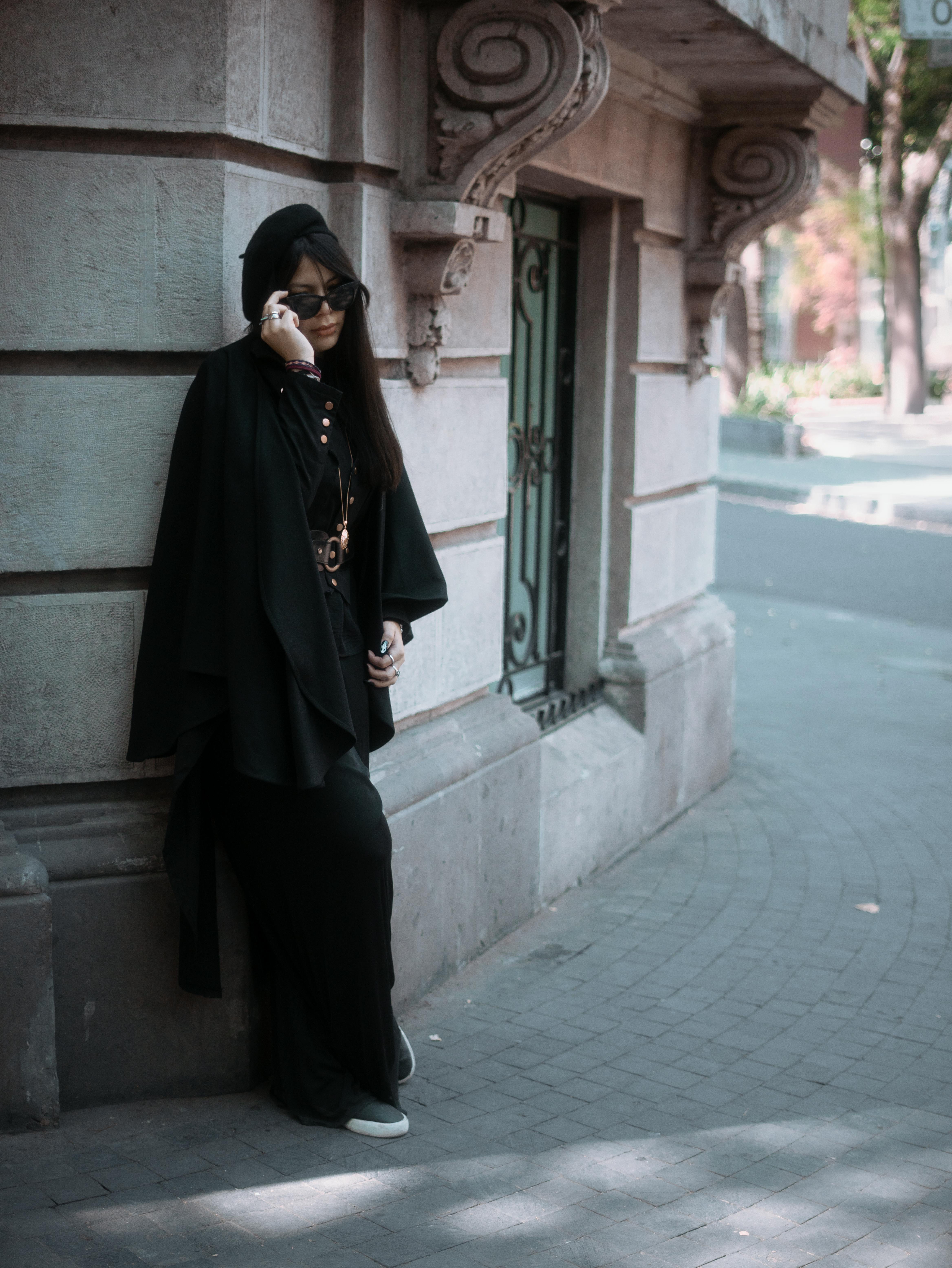 Gratis Un'elegante donna in abito nero posa in una strada di Città del Messico, sfoggiando un look urbano. Foto a disposizione