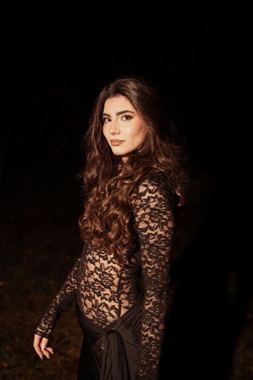 Free A portrait of an elegant woman in a black lace outfit captured at night, showcasing fashion and beauty. Stock Photo