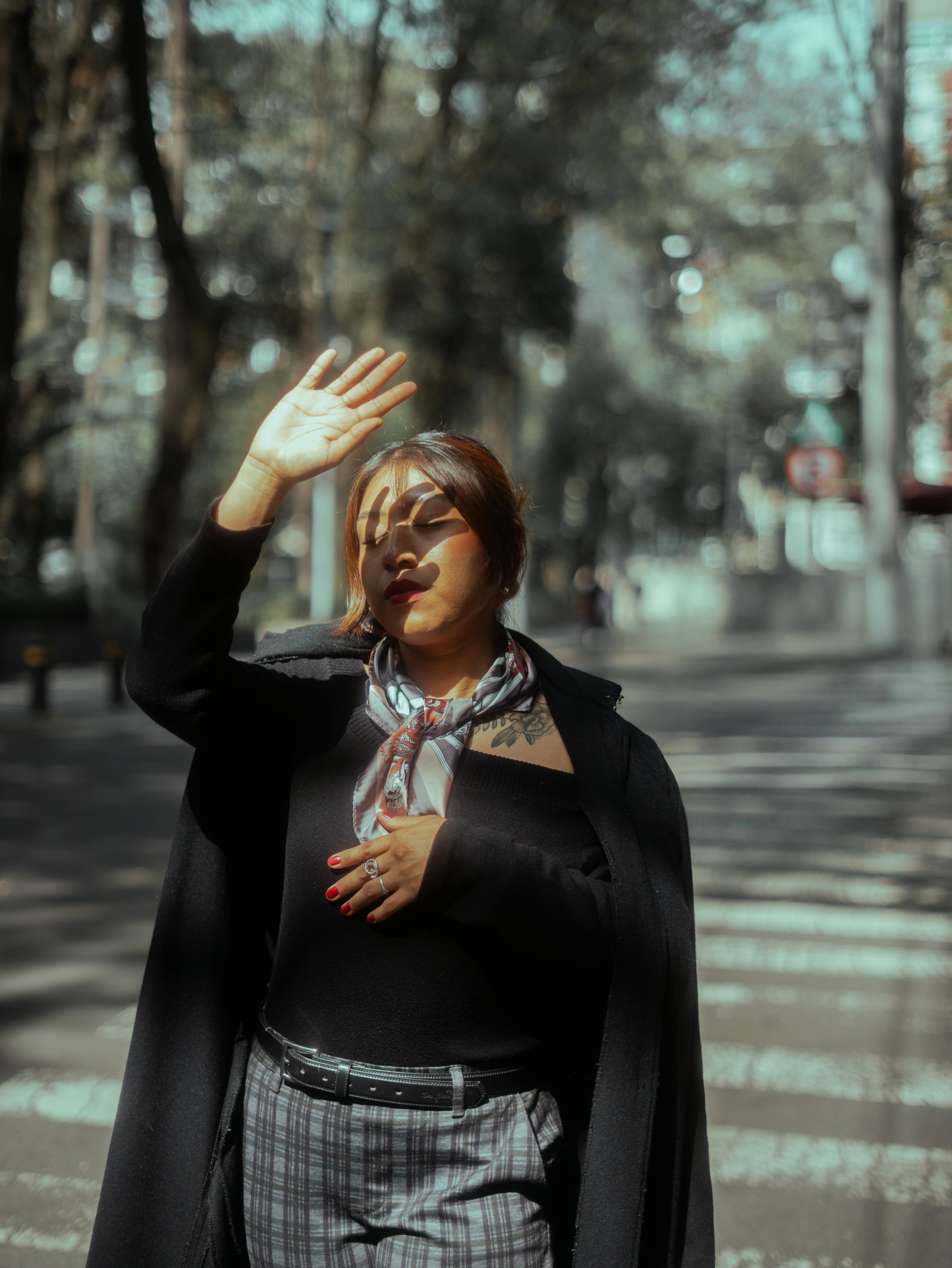 ingyenes Stílusos, fekete ruhás nő kecsesen pózol egy napsütéses napon Mexikóváros városi parkjában. Stockfotó