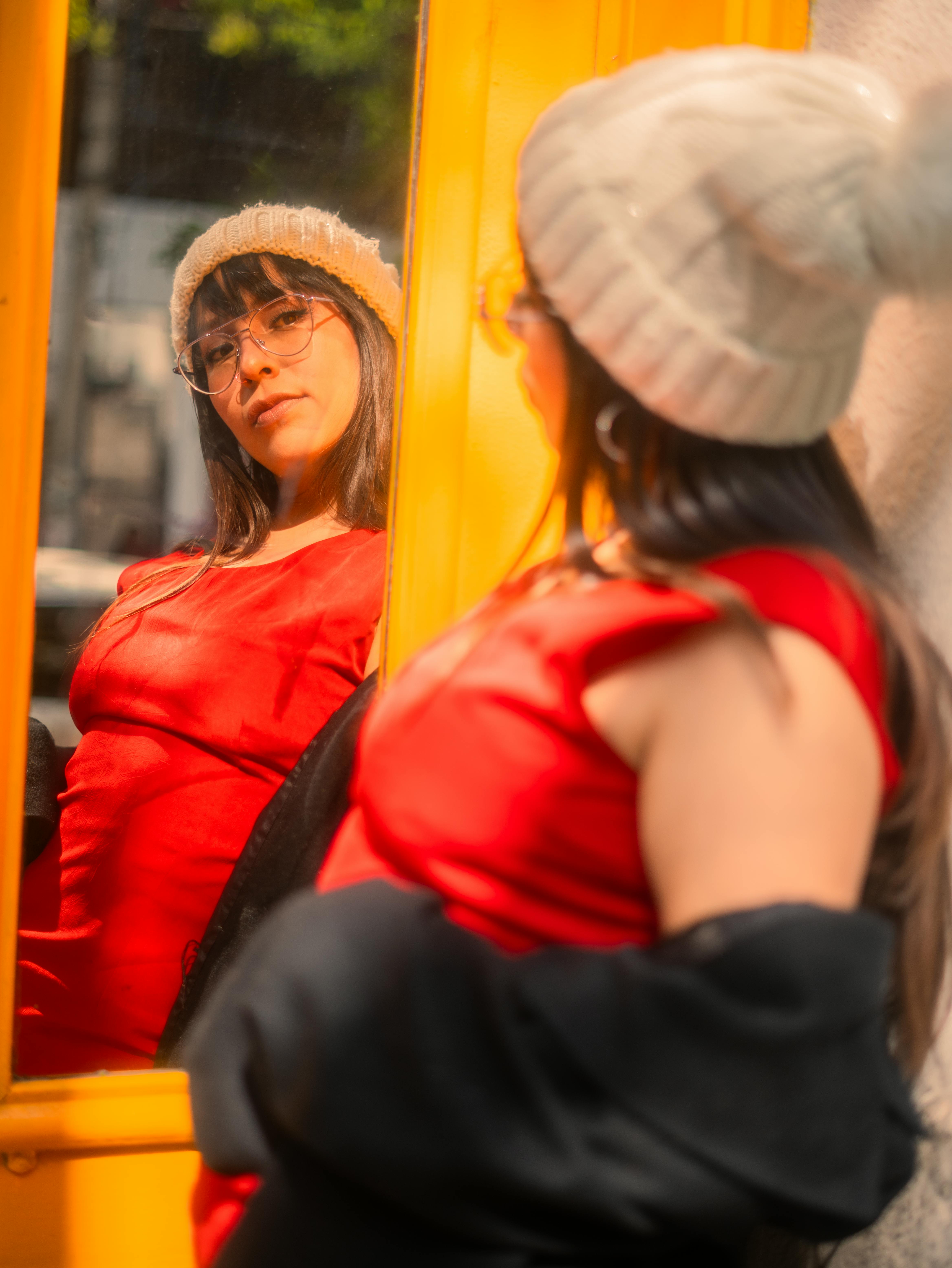 Gratis Elegante ritratto di una donna con un abito rosso e un cappello, riflessa in uno specchio a Città del Messico. Foto a disposizione