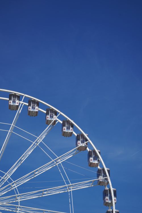 Free A large Ferris wheel ascending into a clear blue sky, symbolizing joy and adventure. Stock Photo
