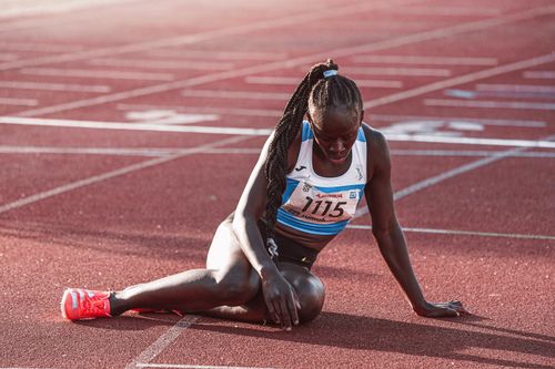 Free A female athlete in sports gear taking a break on the running track after a race, during daylight. Stock Photo