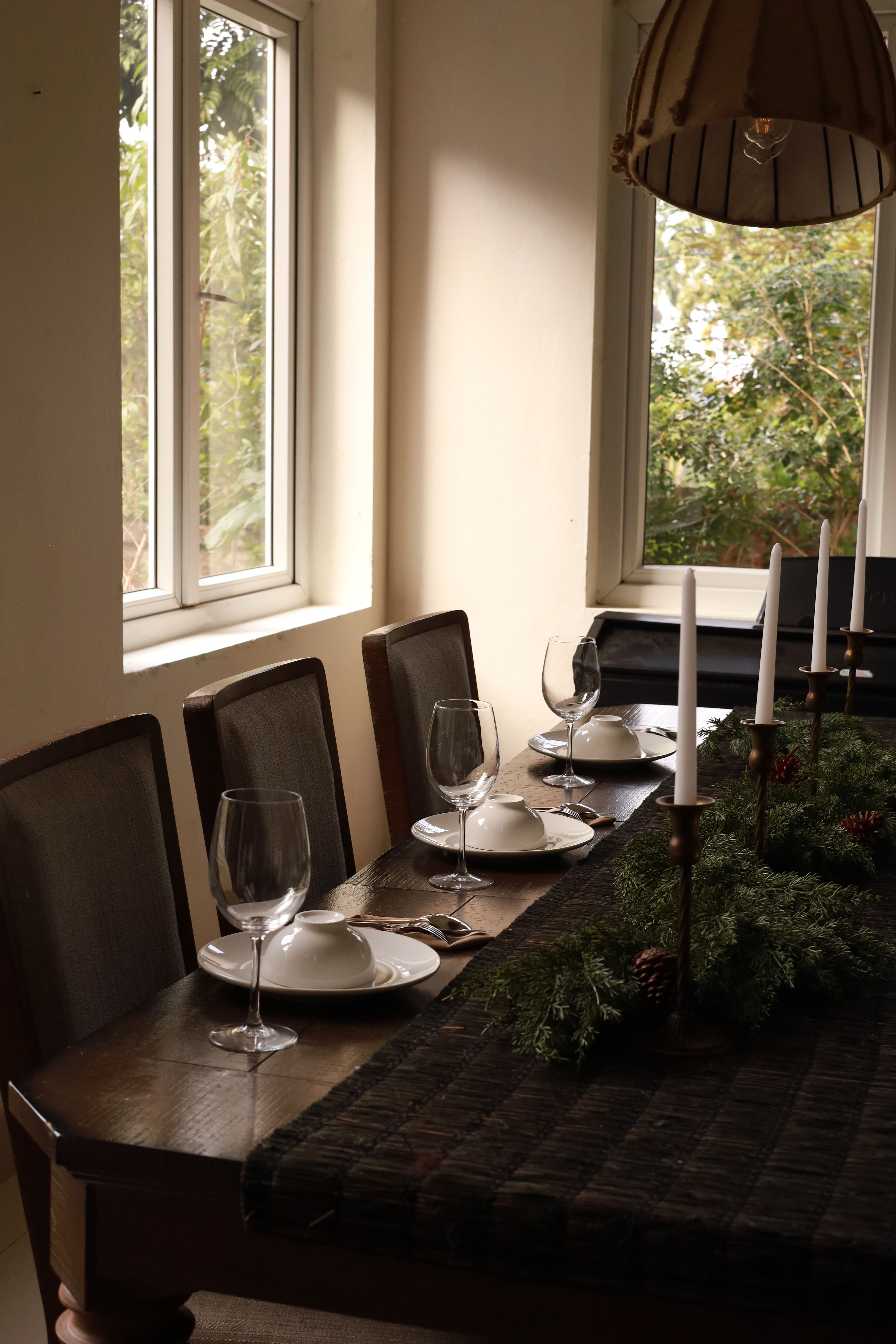 Sophisticated dining table setup with plates, glasses, and candles, capturing a festive holiday ambiance.