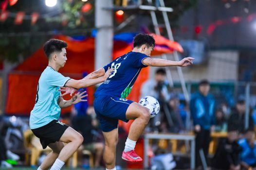 Dynamic football players in action during a game in Hà Nội, showcasing athleticism and teamwork.