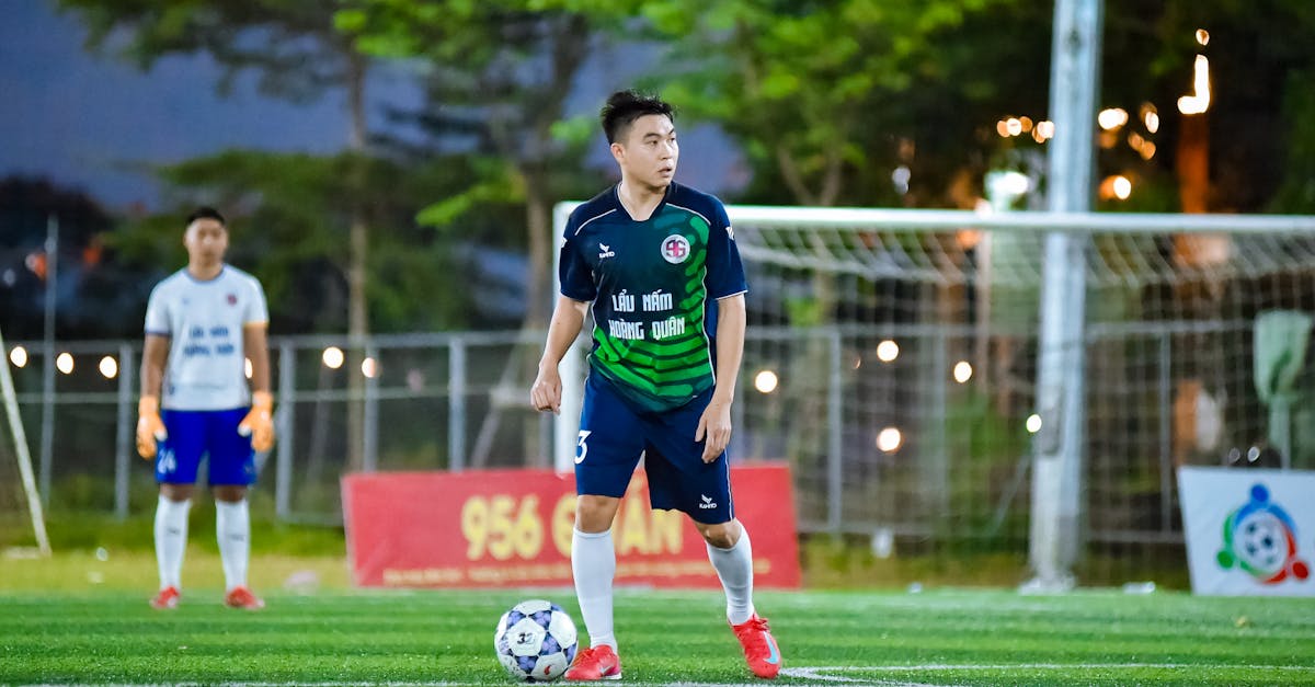 Photo by ANH LÊ Live football match in Hà Nội with players in dynamic action under stadium lights.