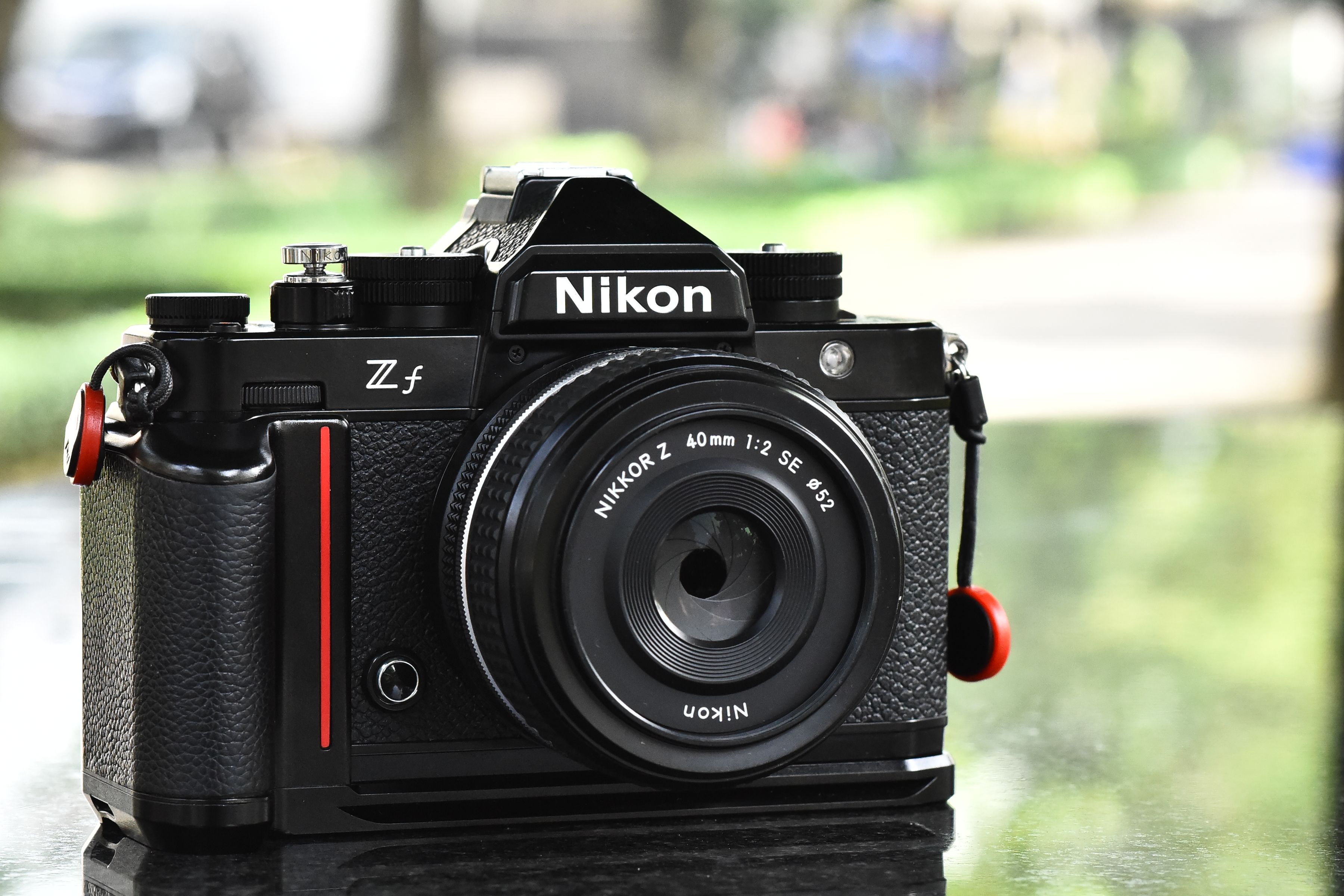 Detailed shot of a classic Nikon camera with Z f lens, outdoors.