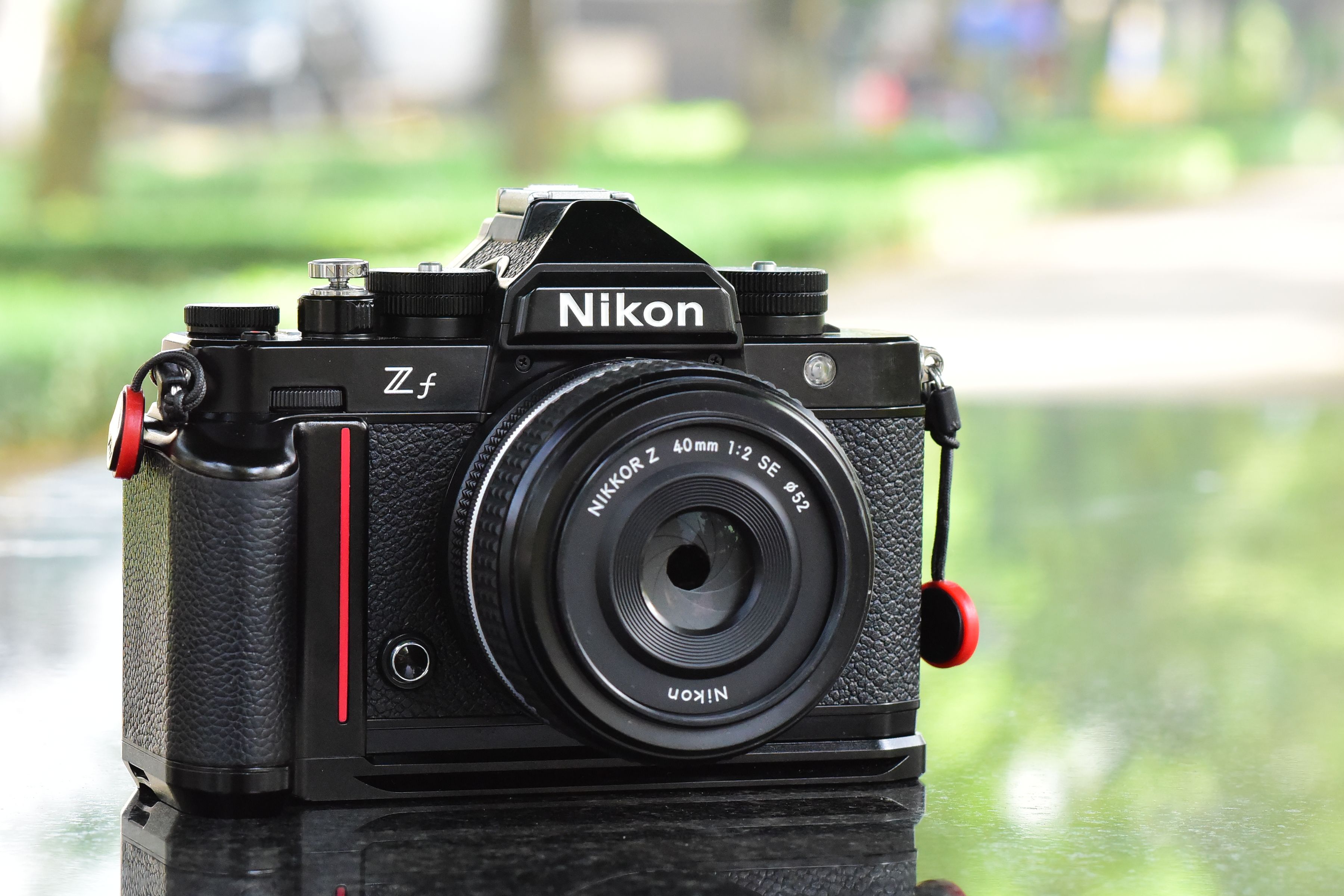 Close-up of a Nikon Zf camera with a 40mm lens, showcasing sleek design outdoors.