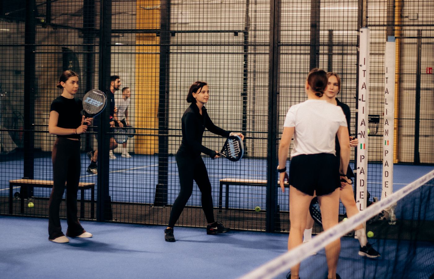 Padel players preparing for a session beside the court