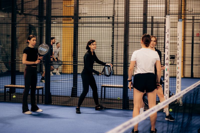 Padel-Spieler auf einem beleuchteten Platz bei Nacht