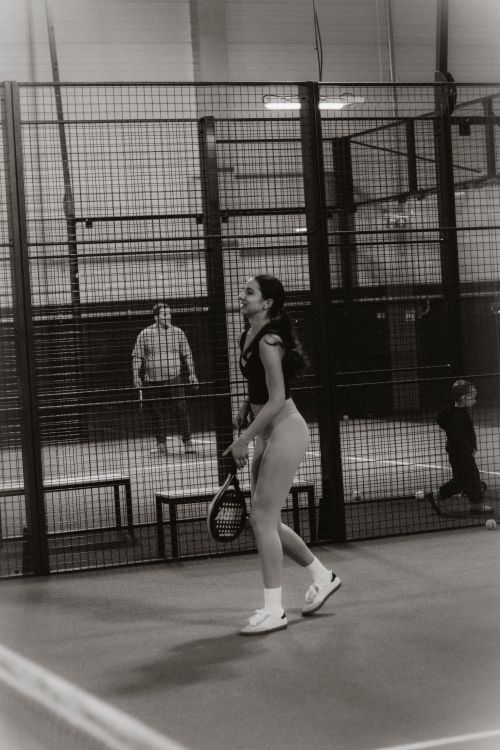 Free Young woman enjoying an intense indoor tennis match in a sports facility. Stock Photo