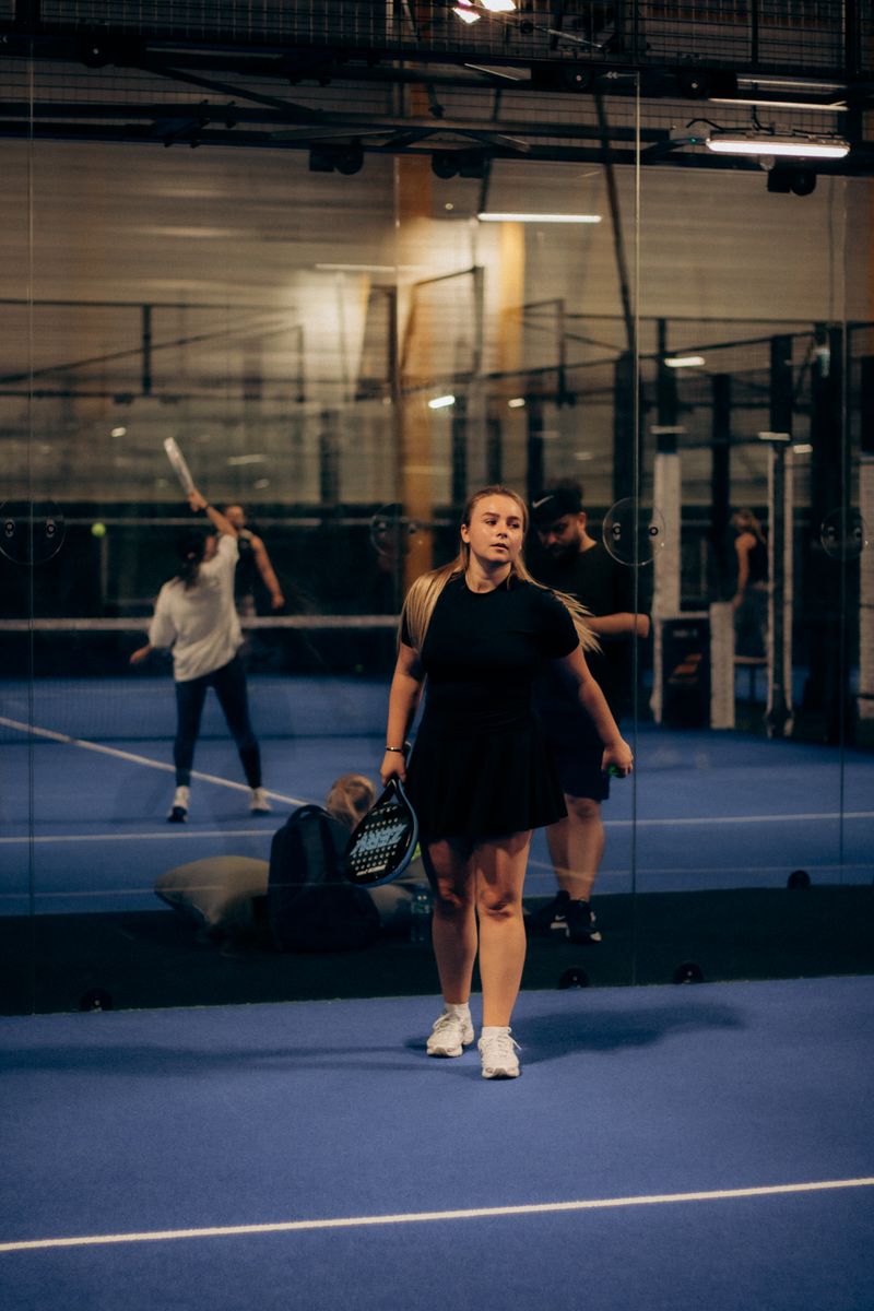 Player arriving at an indoor padel court, the door already unlocked for her booked slot