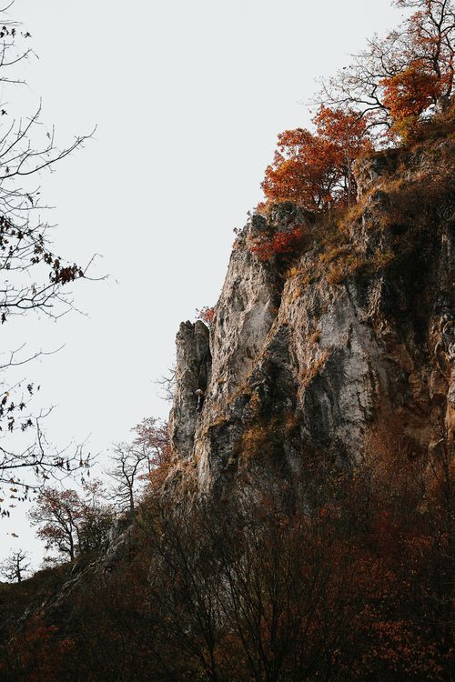Free Discover the rugged beauty of a rock cliff adorned with autumn foliage in Hungary. Stock Photo