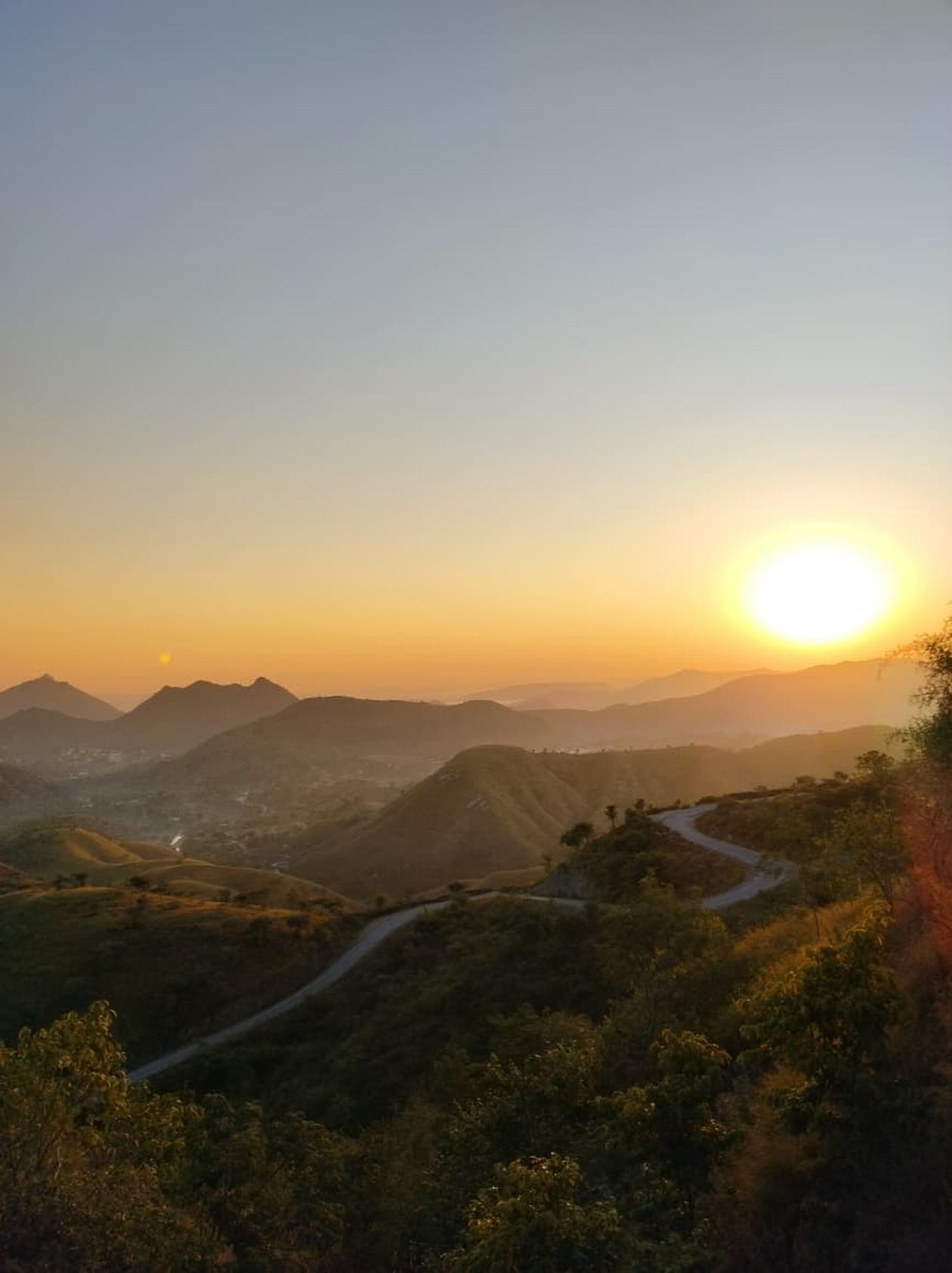 Winding road through the Aravalli hills near Udaipur at sunset on the Ahmedabad to Udaipur road trip