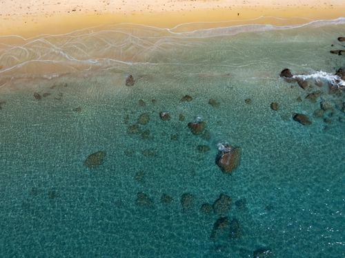 Free Stunning aerial view of Glyfada Beach in Greece, showcasing its azure waters and sandy shores. Stock Photo