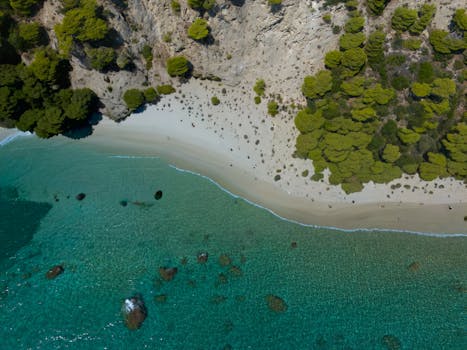 Stunning aerial shot of Glyfada Beach, Greece showcasing turquoise waters and rocky coastline.