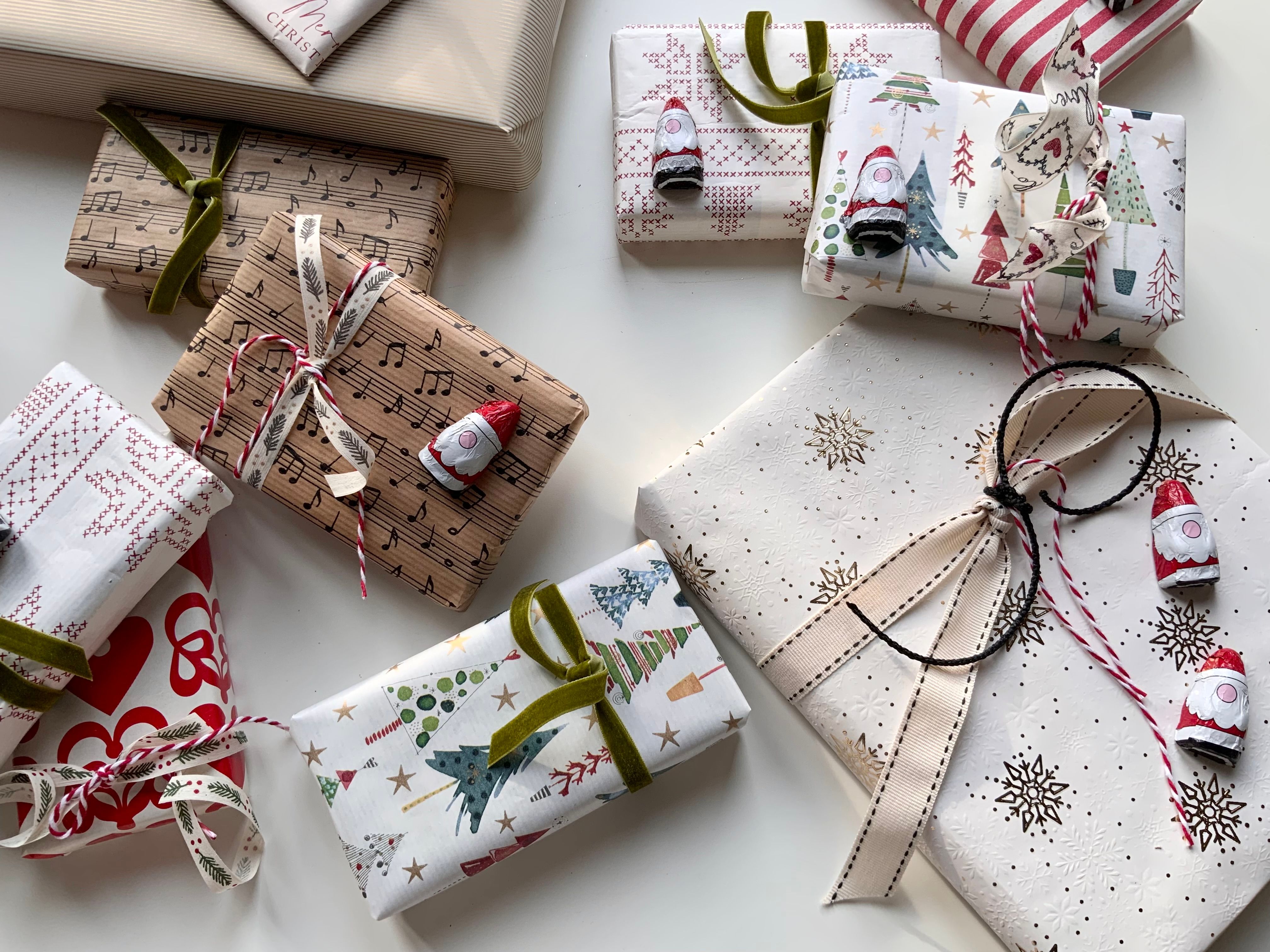 Top view of elegantly wrapped Christmas presents with various festive paper designs and ribbons.