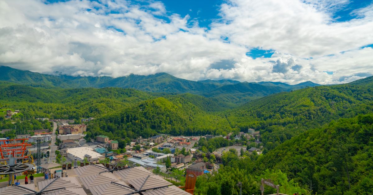 Breathtaking aerial view of lush Smoky Mountains and Gatlinburg cityscape during summer.