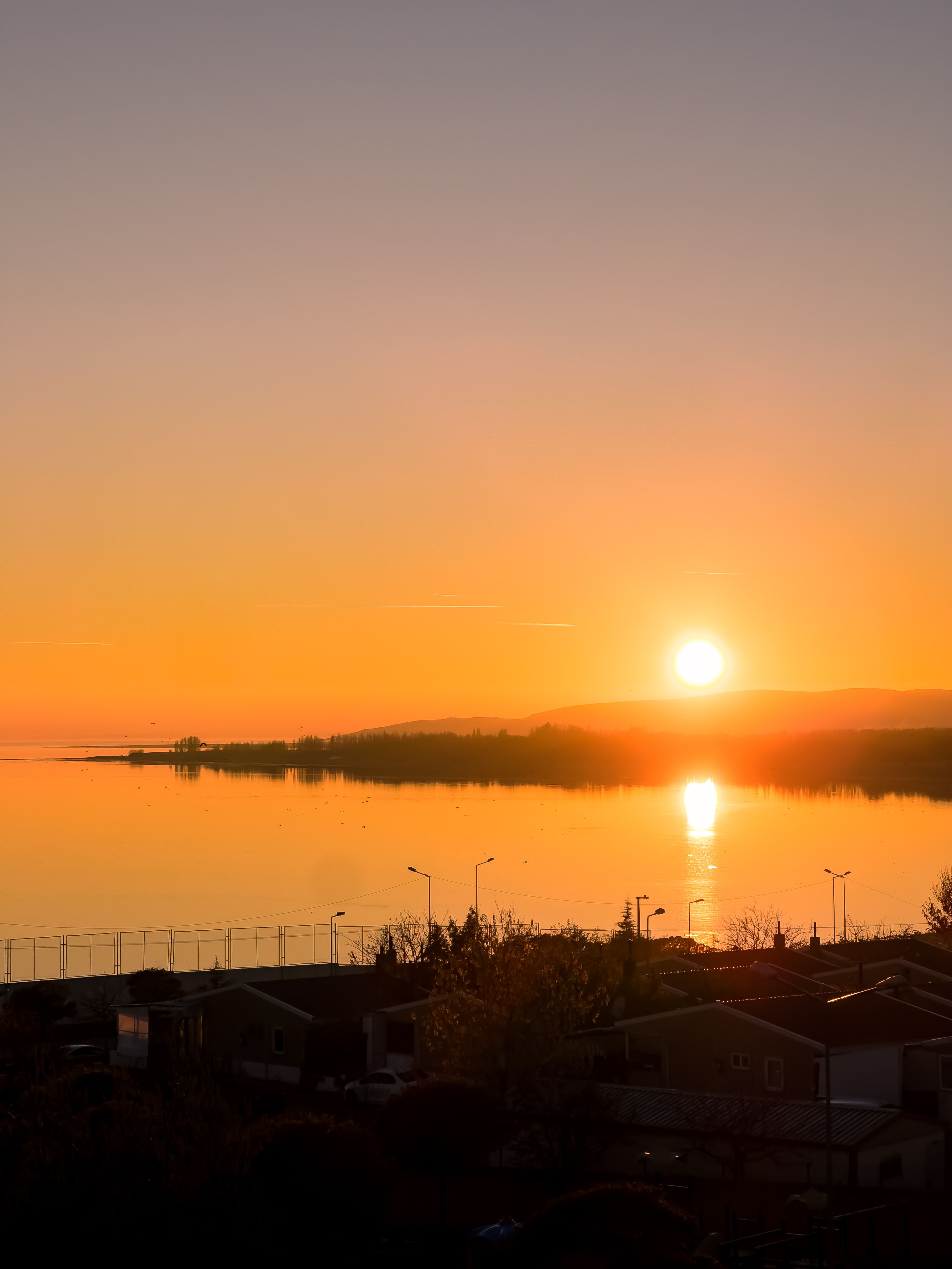 Beautiful sunset over a serene lake, reflecting warm colors of the sky.