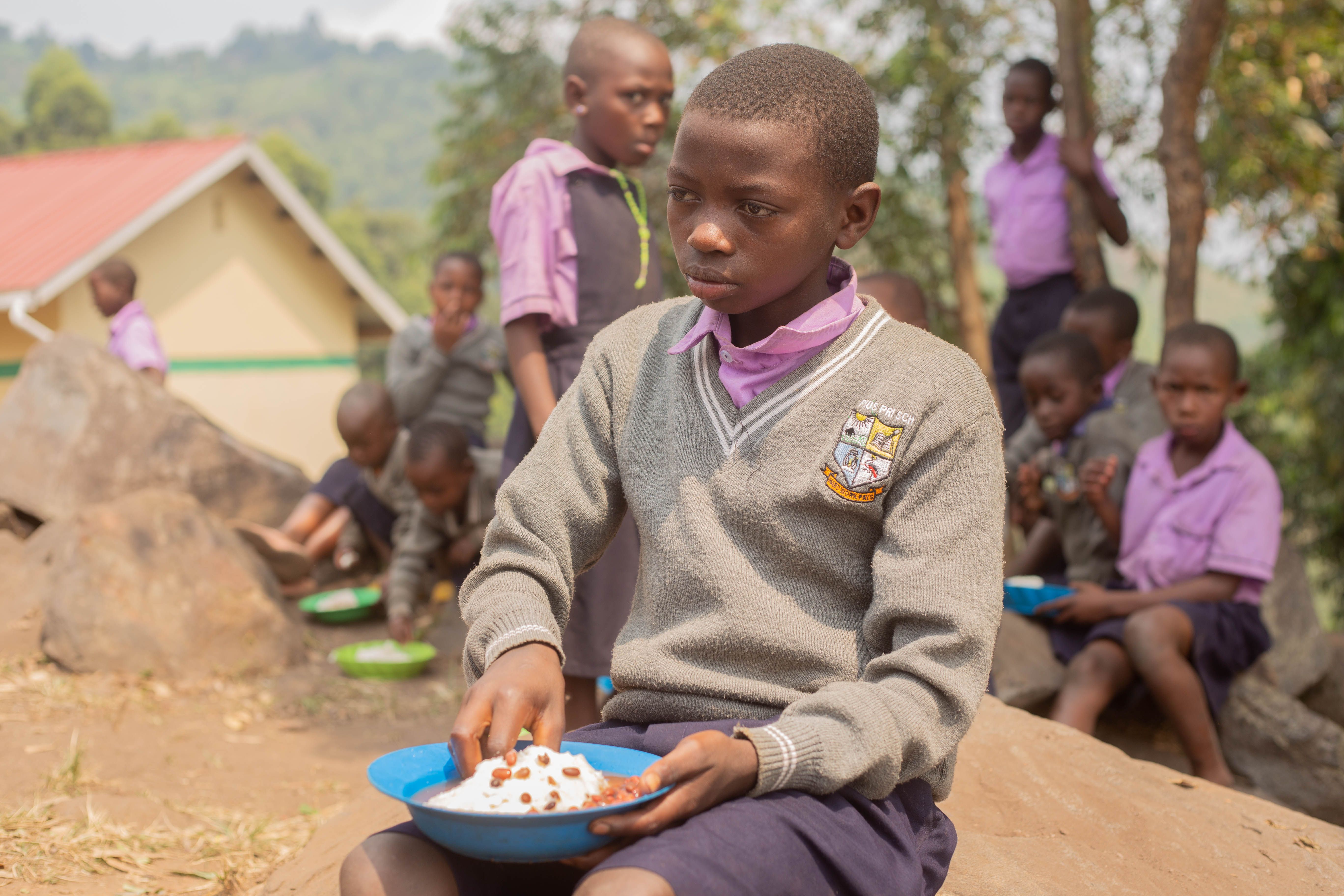 Children queuing with plates for a shared school lunch