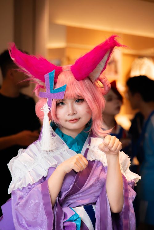 Free Person in colorful anime costume with pink hair and fox ears at a convention. Stock Photo