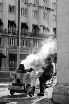Monochrome image of a street vendor roasting chestnuts in Lisbon.