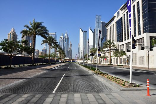 Captivating view of Dubai's skyline with modern architecture and palm trees lining a city street.