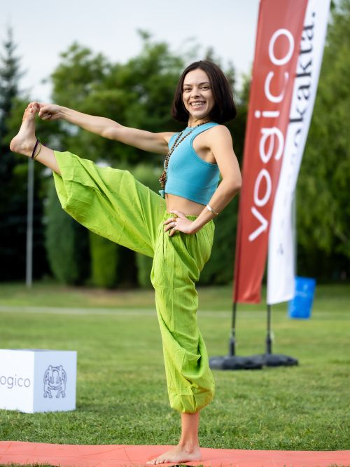 Free Young woman practicing yoga pose outdoors on a sunny day in a park setting. Stock Photo