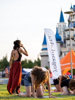 Yoga session in a park with a scenic castle backdrop, capturing serene and active lifestyles.