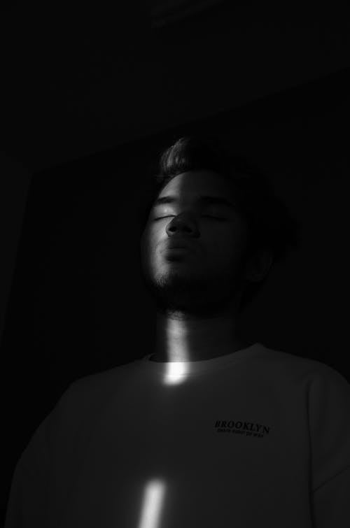 Grayscale Photography of Man Wearing Crew-neck T-shirt While Closing His Eyes