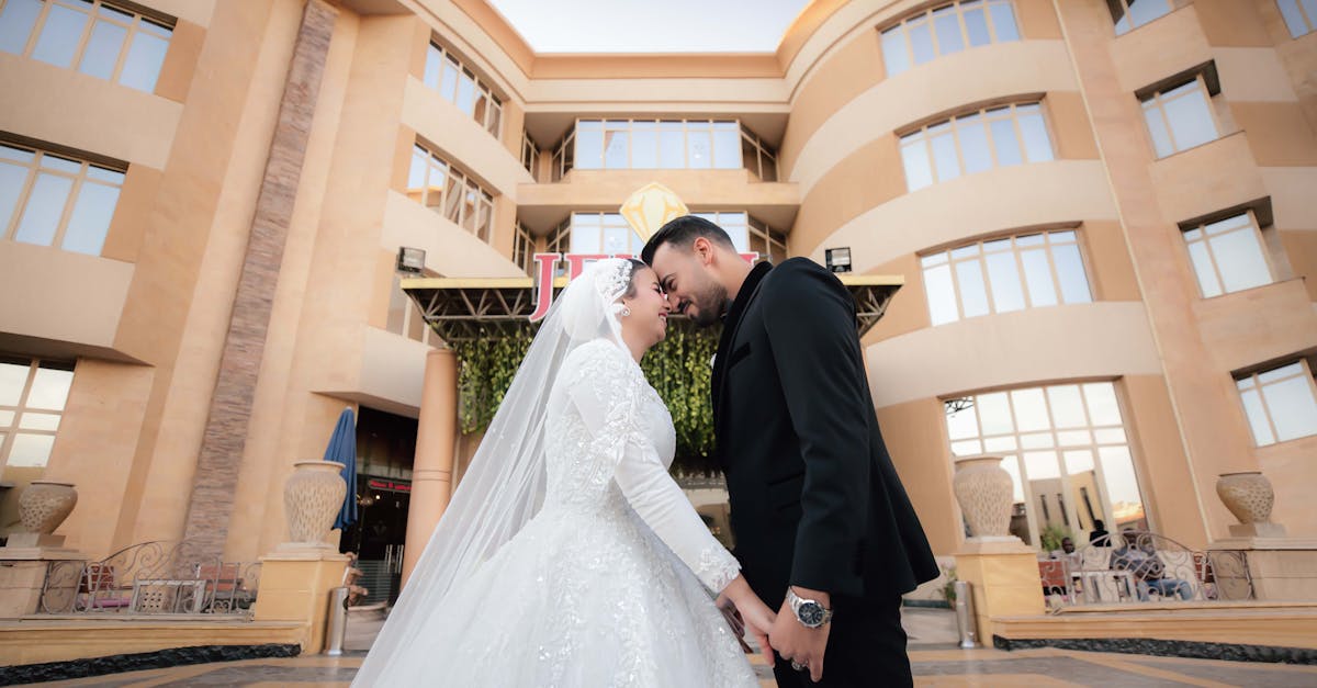 Bride and groom share a moment at an elegant outdoor wedding venue with modern architecture.