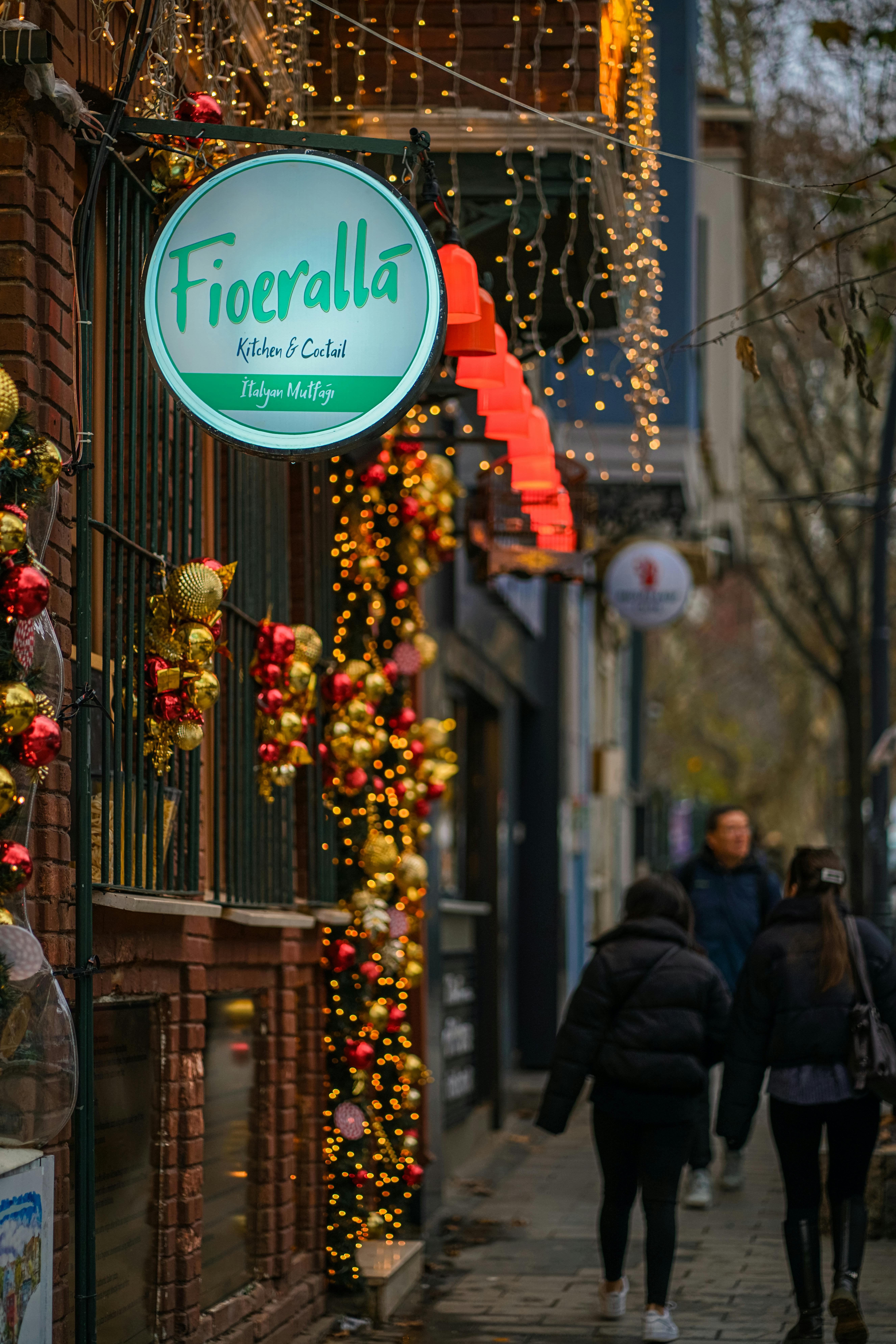 Gratis Suggestiva vista di una strada festosa, adornata con luci e decorazioni natalizie, che invita i passanti. Foto a disposizione