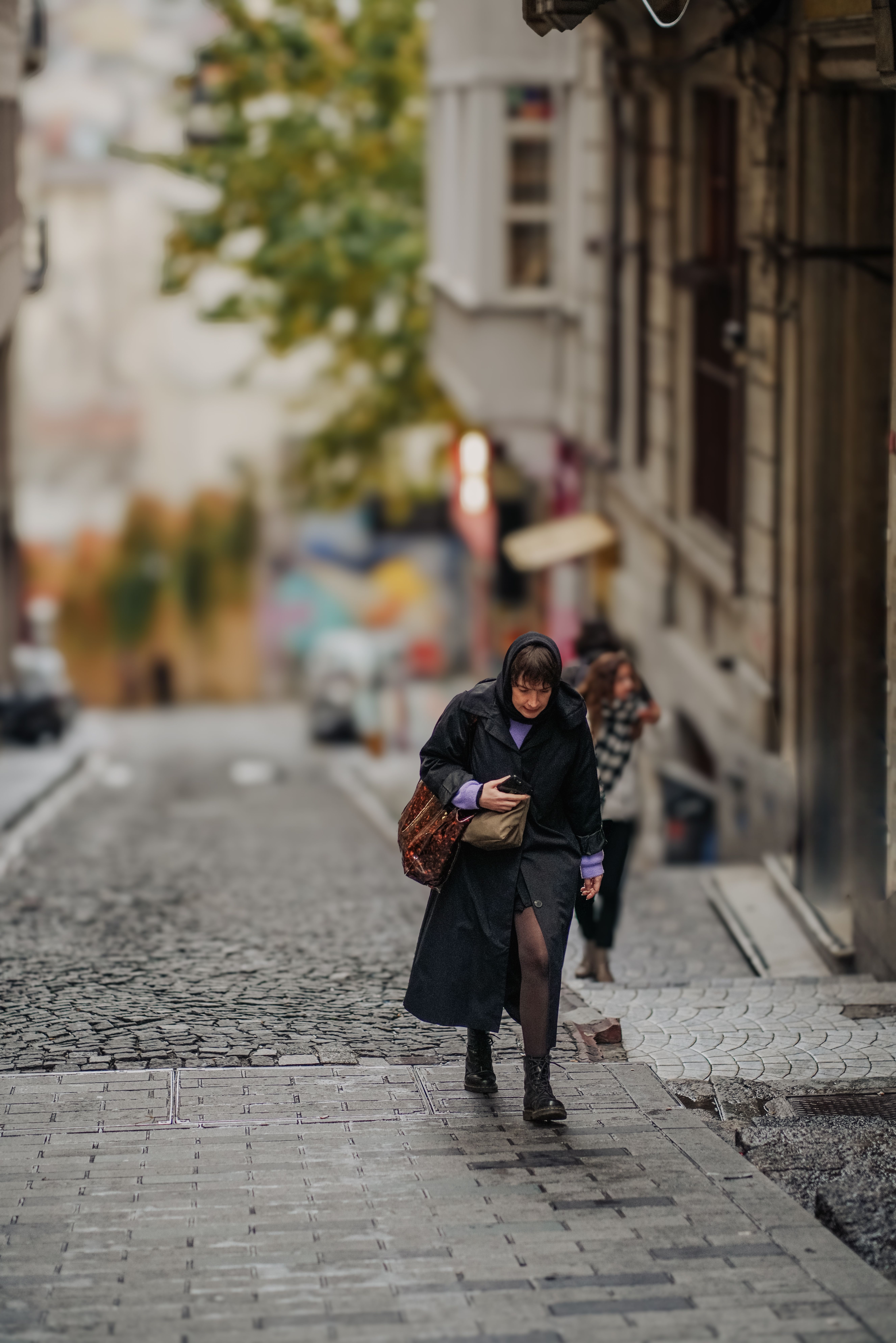 Woman Walking on Cobblestone Street in Urban Setting · Free Stock Photo