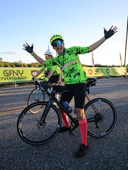 Joyful cyclists pose with bikes at the GFNY Puerto Rico race under clear skies.
