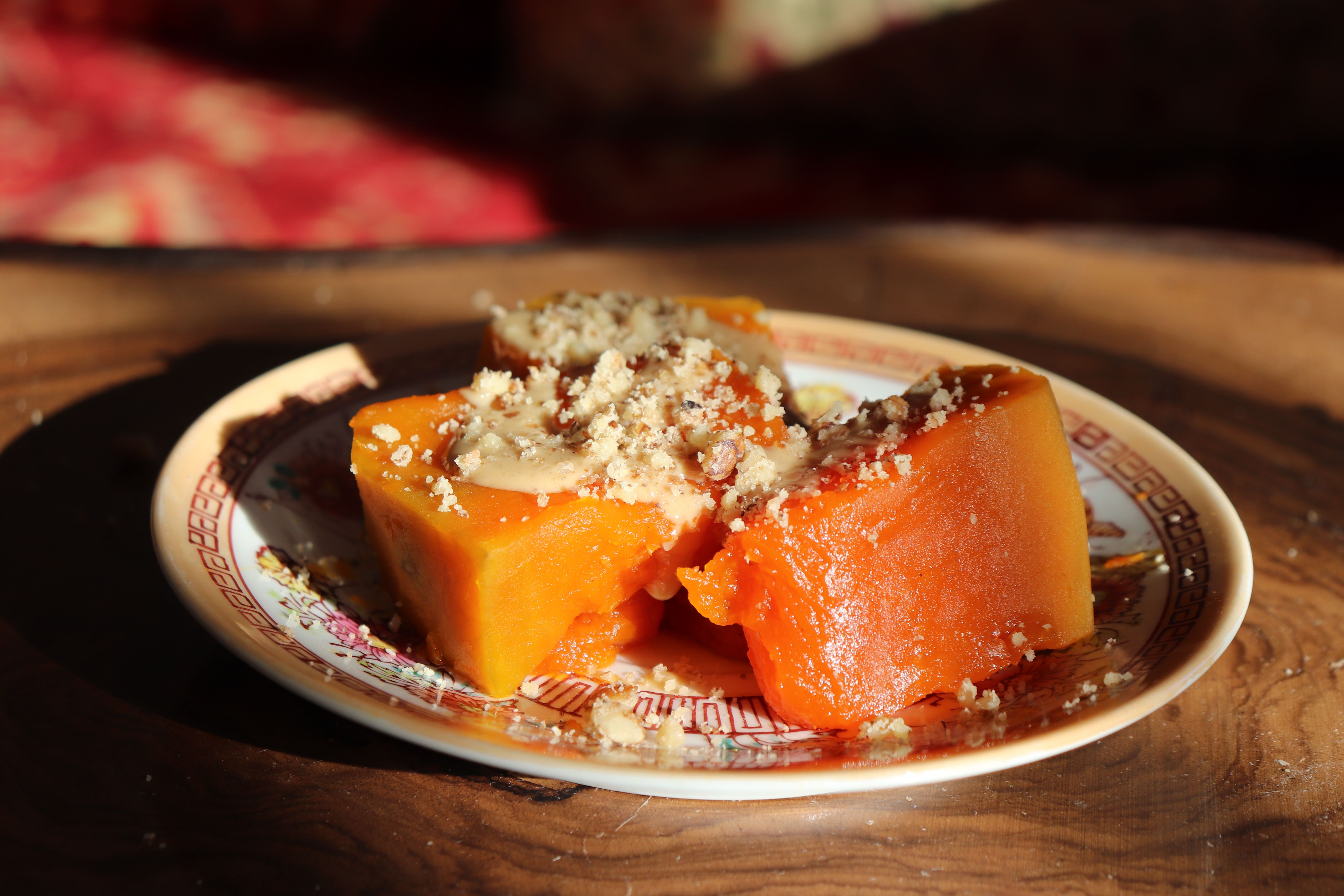 A close-up of Omani Halwa, a traditional gelatinous sweet made with saffron, cardamom, and nuts, served in a decorative bowl.