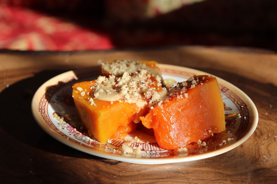 A close-up of Omani Halwa, a traditional gelatinous sweet made with saffron, cardamom, and nuts, served in a decorative bowl.