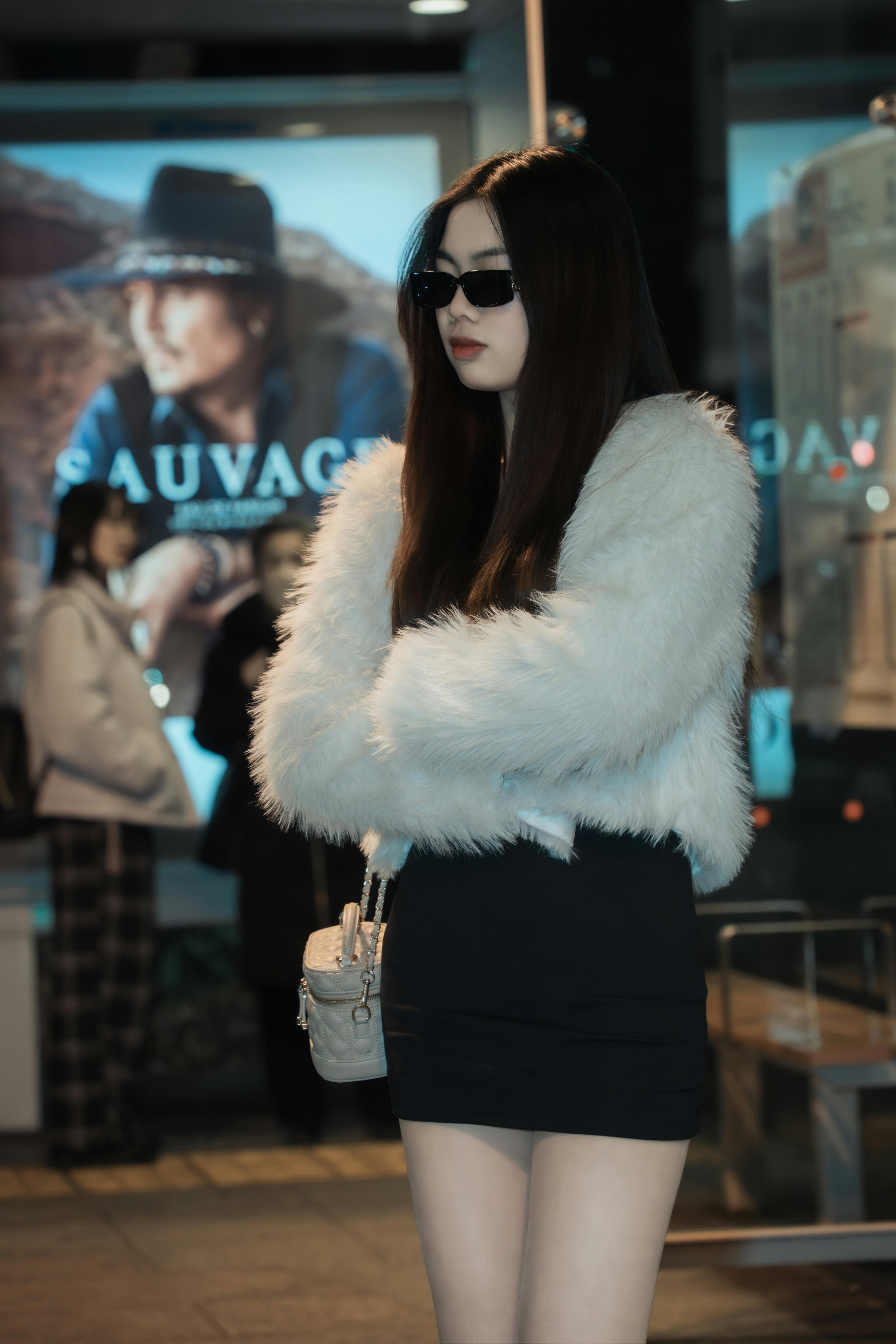 Kostnadsfria Modern kvinna med solglasögon och pälskappa i staden under natten. Stock foto