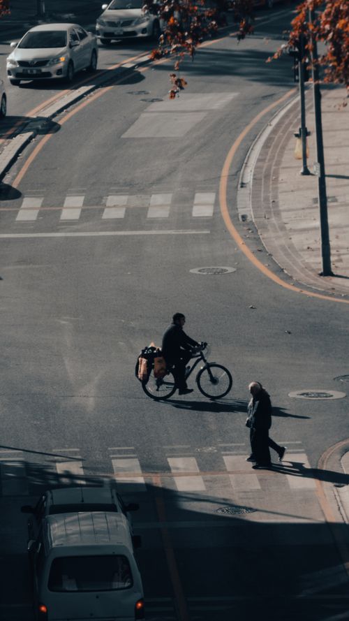 Free Aerial view of a city intersection with a cyclist and pedestrian crossing. Stock Photo