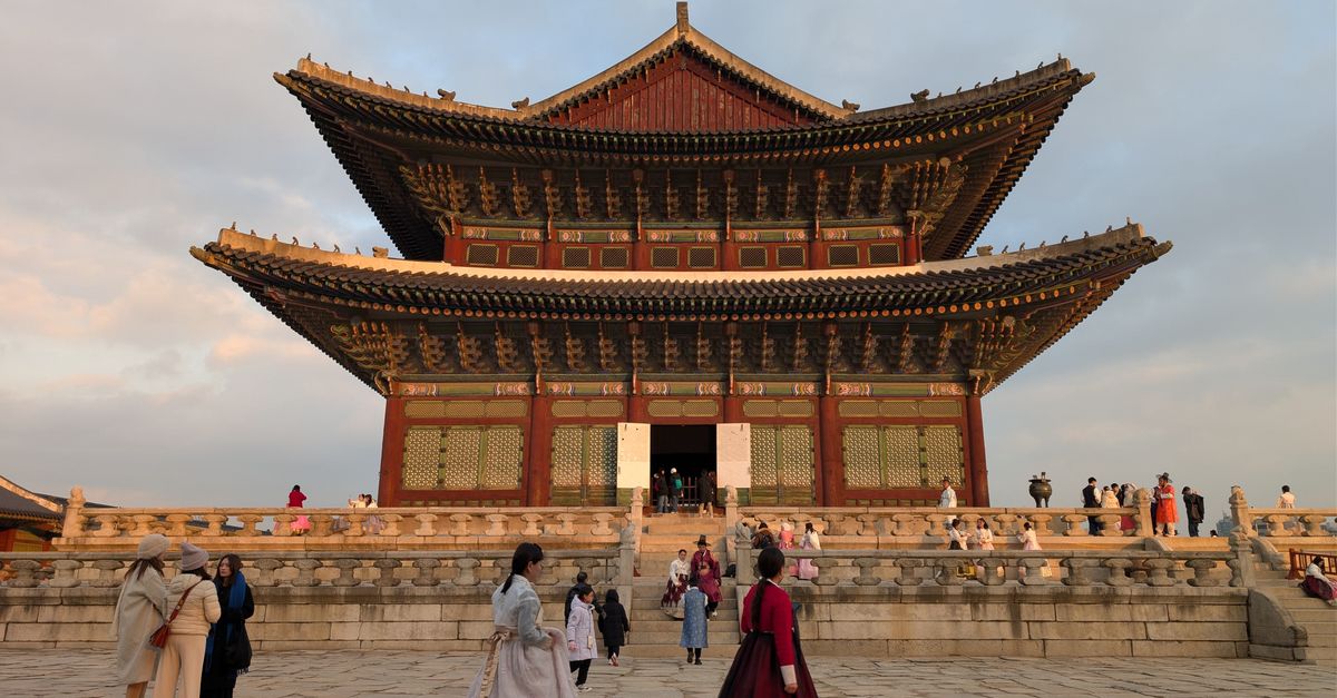 Visitors in Hanbok at Gyeongbokgung Palace, Seoul, during sunset capturing Korean culture and architecture. visual (Photo: Luiz M / Pexels)