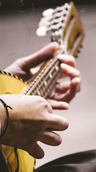 Detailed close-up of hands skillfully playing a mandolin, emphasizing musical artistry.