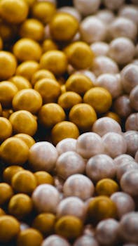 Close-up of golden and white beads creating a textured aesthetic, perfect for backgrounds or design.