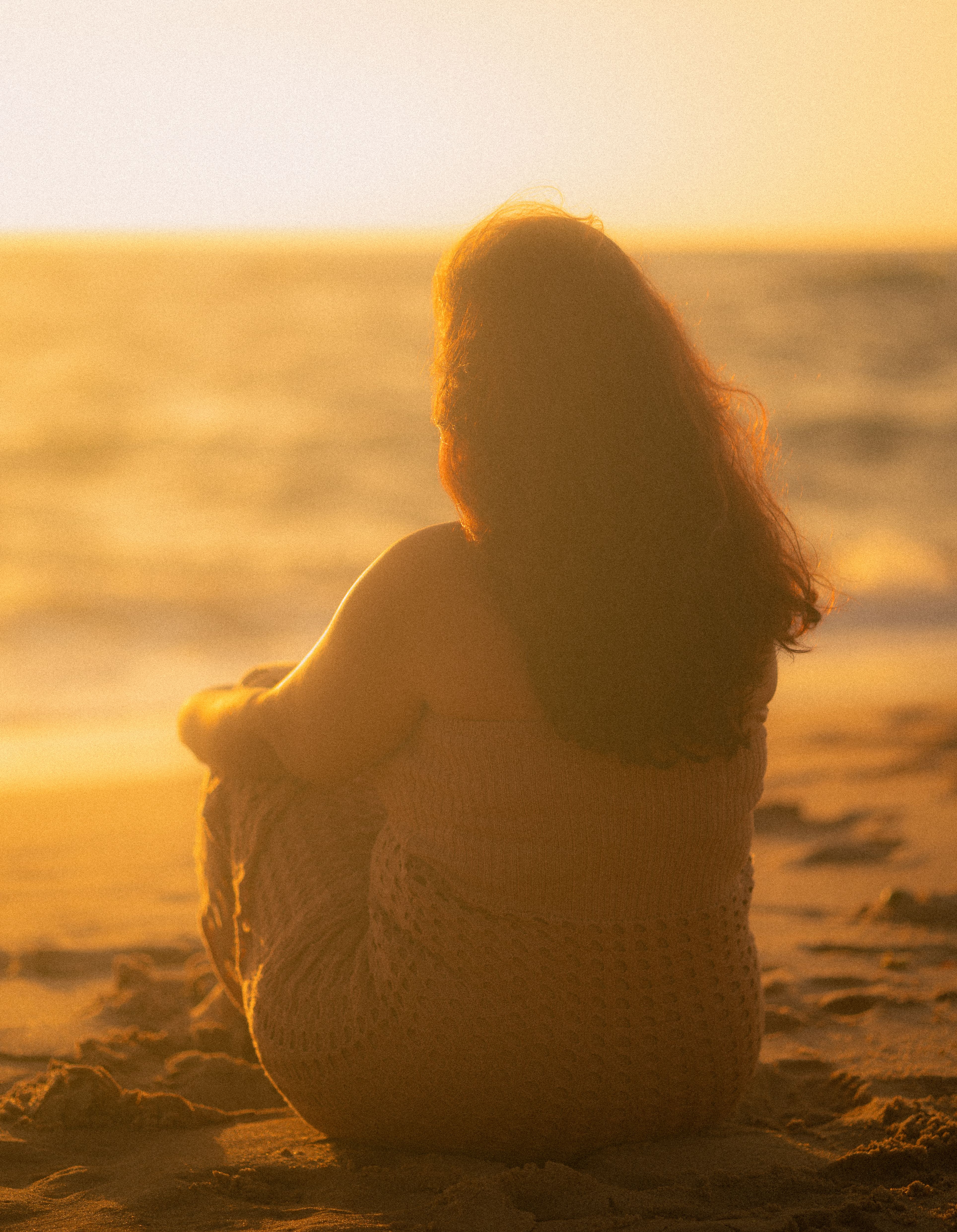 Back View of Blonde Woman Sitting on Beach at Dusk · Free Stock Photo