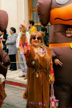 Colorful street parade with costumed participants celebrating cultural festivity in San Cristóbal de las Casas.