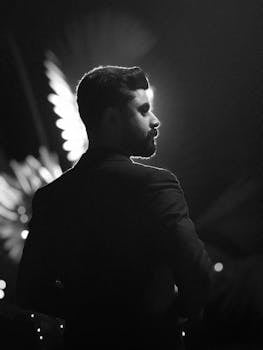 A striking black and white silhouette of a man with dramatic lighting.