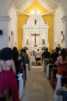 A wedding ceremony inside a beautifully decorated historical church with guests observing the couple.