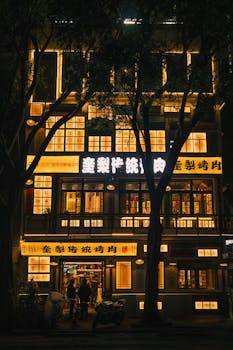 Beautiful night view of a brightly illuminated Asian restaurant with glowing signage and traditional design.