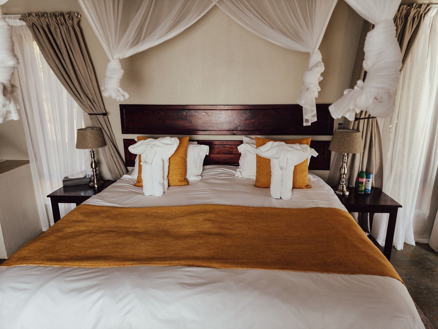 Luxurious bedroom featuring a stylish canopy bed with soft pillows and warm lighting.