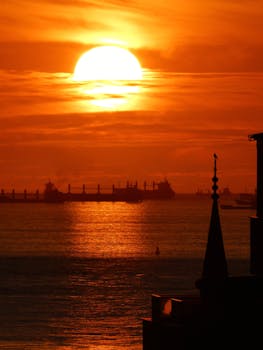 Golden sunset over İstanbul sea with ships and silhouette skyline.