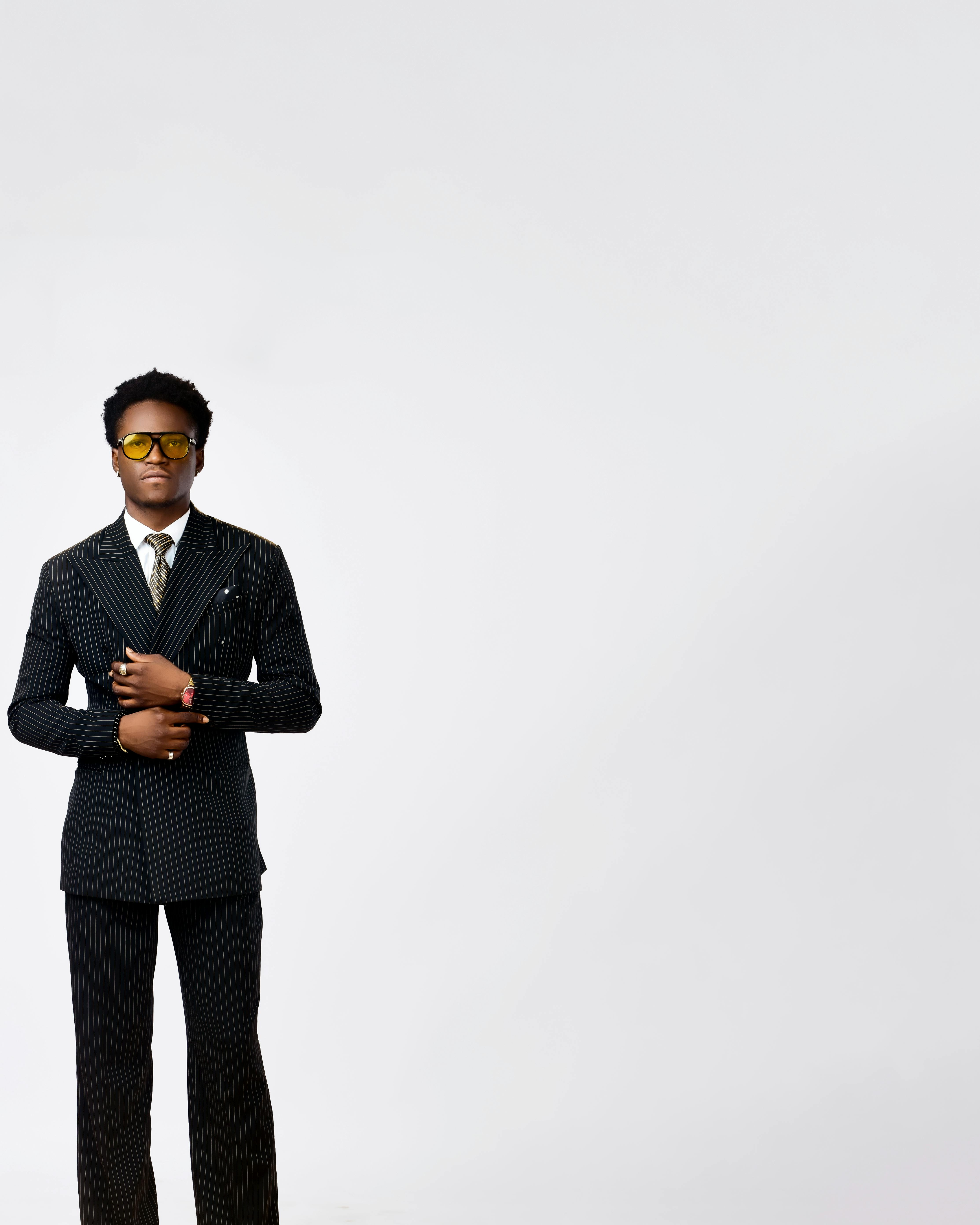 gratis Portret van een stijlvolle, volwassen zakenman in een krijtstreepkostuum en zonnebril, die zelfvertrouwen uitstraalt. Stockfoto