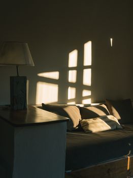 Warm evening sunlight casts geometric shadows in a minimalist interior setting.